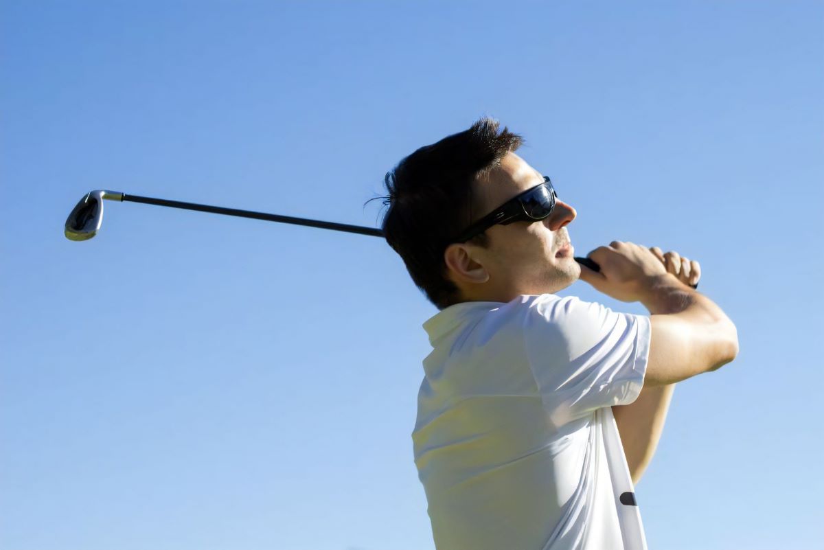 ゴルフのスイングをする男性